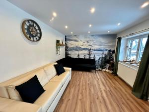 a living room with a couch and a clock on the wall at Ferienhaus Luisl & Hilde in Unterammergau