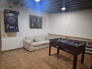 a living room with a couch and a dart board at La Casona del Rio Abion in Valdealvillo