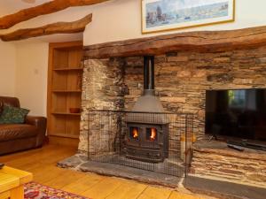 a stone fireplace in a living room with a tv at East Bickleigh in Totnes