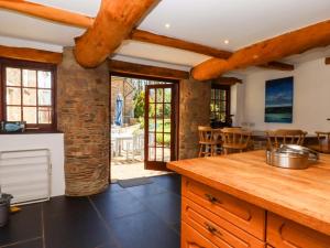 an open kitchen with wooden beams and a dining area at East Bickleigh in Totnes