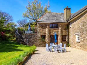 a table and chairs in front of a stone house at East Bickleigh in Totnes