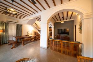 a living room with a table and a dining room at Elegant holiday homes Coorg in Somvārpet