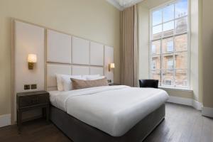a hotel room with a large bed and a window at Blythswood Square Apartments in Glasgow
