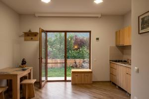 a kitchen with a large glass door leading to a yard at Mountain Horizon in Borjomi +21 photos