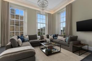 a living room with a couch and a tv at Blythswood Square Apartments in Glasgow