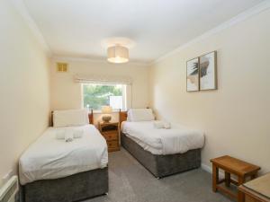 a bedroom with two beds and a window at Beech Timber Lodge in Keswick