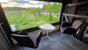 a room with chairs and a table and a large window at Hangar Hangout by the Lake in Priles
