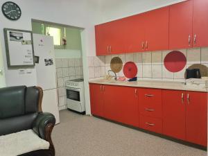 a kitchen with red cabinets and a white refrigerator at Artisan Center Apartment Peja in Peje