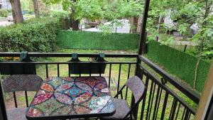 a patio with a table and chairs on a balcony at Artisan Center Apartment Peja in Peje