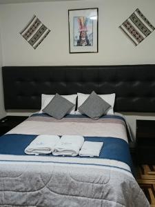 a bedroom with a bed with two towels on it at HOTEL San Antonio in Puno