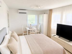 a bedroom with a large bed and a flat screen tv at D&C Norway in Kristiansand
