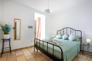 a bedroom with a large bed with blue pillows at Villa con piscina Seychelles del Salento in Marina di Pescoluse