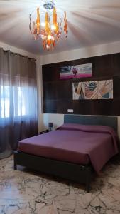 a bedroom with a large bed and a chandelier at Casa dell'Aloe in Angri