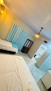 a bedroom with two beds and a desk in it at Pousada Imperio Azul in Santo Amaro