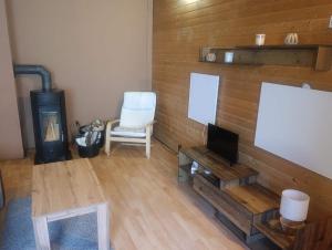 a living room with a tv and a chair at Chata Čertovy hlavy in Želízy