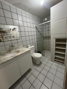 a white bathroom with a toilet and a sink at Jampa Pousada Sb in João Pessoa