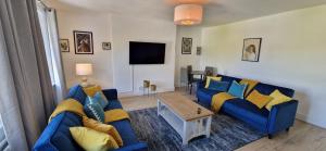 a living room with a blue couch and a table at Chic 1BR Teddington Apartment Modern & Bright in Kingston upon Thames