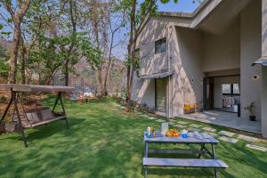 a picnic table in the yard of a house at SaffronStays Pickle & Play in Khandāla