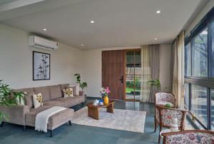 a living room with a couch and a table at SaffronStays Pickle & Play in Khandāla