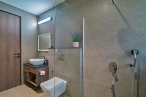 a bathroom with a shower with a toilet and a sink at SaffronStays Pickle & Play in Khandāla +11 photos