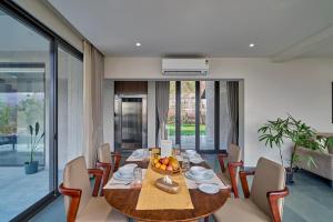 a dining room with a table with a bowl of fruit on it at SaffronStays Pickle & Play in Khandāla