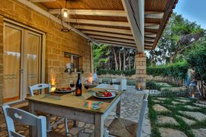 an outdoor dining area with a table and chairs at Villa con piscina Seychelles del Salento in Marina di Pescoluse