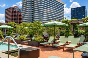 a patio with chairs and umbrellas next to a pool at The Barnett JDV by Hyatt in New Orleans