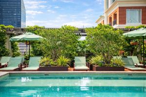 a swimming pool with chairs and umbrellas on a building at The Barnett JDV by Hyatt in New Orleans