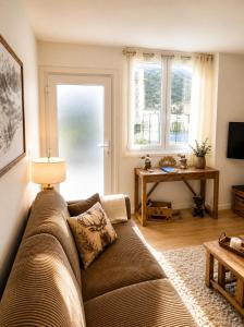 a living room with a couch and a table at La Marmotte appartement cosy centre Briancon proche Prorel in Briançon