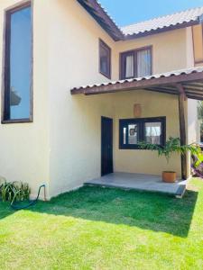 a house with a green lawn in front of it at Villa Coco e Sol - Casa com Jacuzzi in Amontada +3 photos