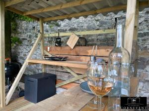 a table with wine glasses and a bottle on it at Appartement scandinave élégant, Domaine Cornevent Lyon, parc & piscine in Vernaison