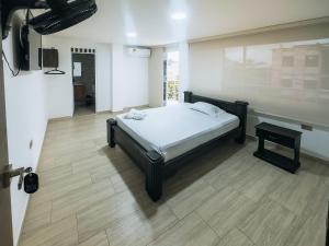 a bedroom with a bed and a tv in a room at Hotel Perla Dorada in San Miguel