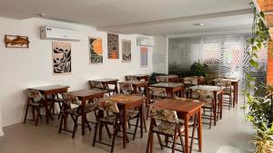 a restaurant with wooden tables and chairs in a room at Pousada Aquarela Do Brasil in Maceió