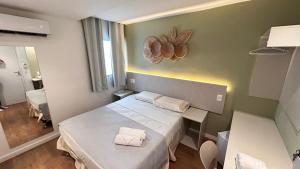 a small room with a bed and a mirror at Pousada Aquarela Do Brasil in Maceió