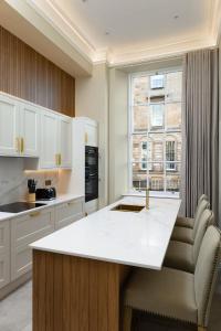 a kitchen with a white counter and a window at Blythswood Square Apartments in Glasgow
