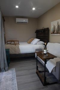 a bedroom with two beds and a table with a bottle of wine at Garden to Table Experience - Unit 101 in Rincon