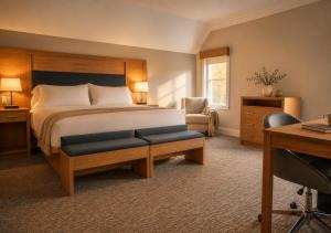a bedroom with a bed and a desk and a chair at The Cape Club Golf Resort in Falmouth
