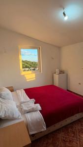 a bedroom with a large bed with a red blanket at Kuća Radović in Budva