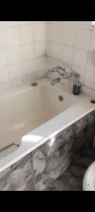 a bathroom with a bath tub with a sink at The Grace and Hope House in Bunkers Hill +3 photos