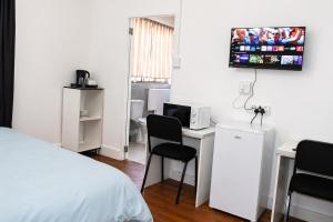 a bedroom with a bed and a desk and a tv at The Grace and Hope House in Bunkers Hill