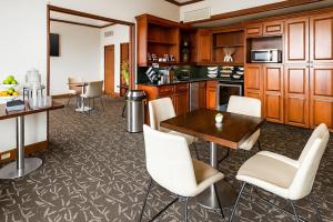 a kitchen with a table and white chairs at The Buckingham Hotel in Chicago