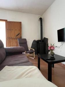 a living room with a couch and a table with flowers at Orgiva - La Alpujarra in Órgiva