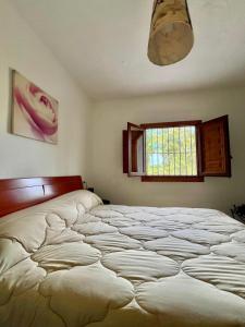 a large bed in a bedroom with a window at Orgiva - La Alpujarra in Órgiva