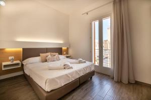 a bedroom with a large bed and a large window at La Dimora del Passante in San Vito lo Capo