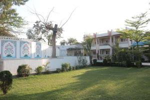 a house with a fence and a yard at Hotel Kalptaru Villas in Debāri +6 photos