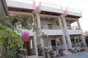a building with a pink flower in front of it at Hotel Kalptaru Villas in Debāri