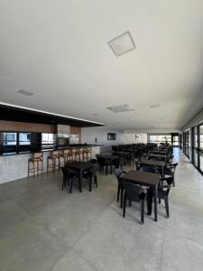 a dining room with tables and chairs in a building at Hotel Bonfim in Silvânia