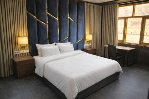 a bedroom with a large bed with a blue wall at Forest Grandeur Resort in Anantnāg +4 photos