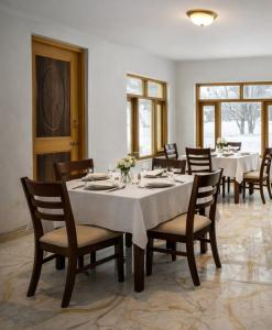 a dining room with a table and chairs and tablesearcher at Forest Grandeur Resort in Anantnāg