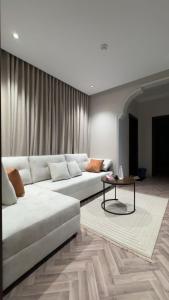 a living room with a white couch and a table at شقة ذا لوكس لوفت 2 in Buraydah